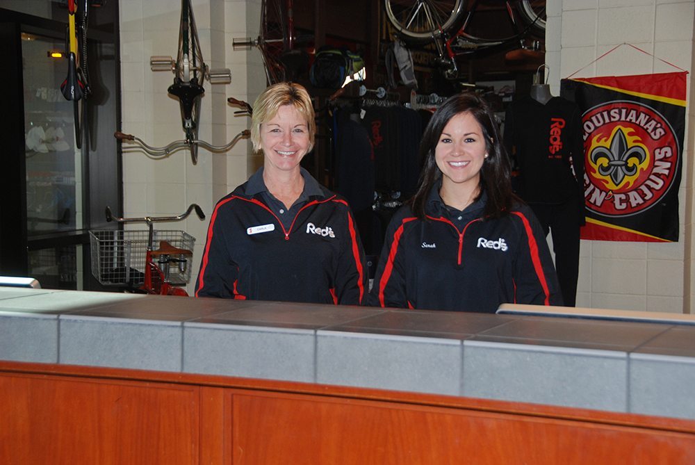 Carla Andrus and Sarah Lebouef, Front Desk/Pro Shop managers standing at the Front Desk at Red Lerille's in Lafayette, La.